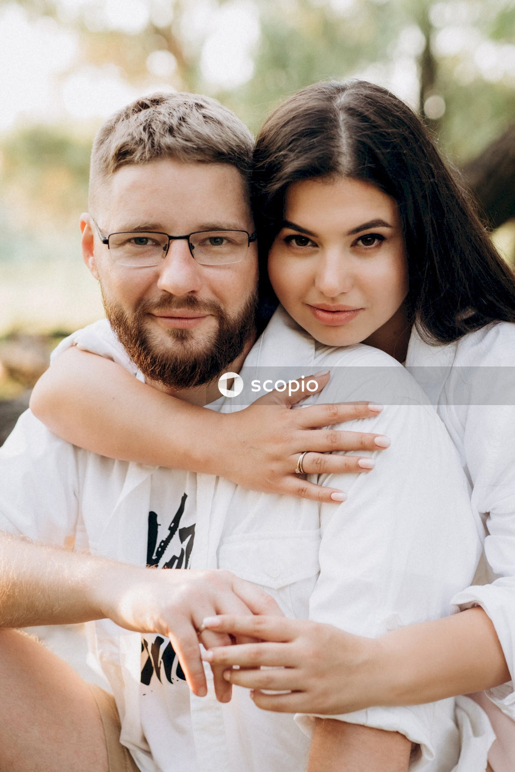 Man in white shirt hugging woman in white shirt
