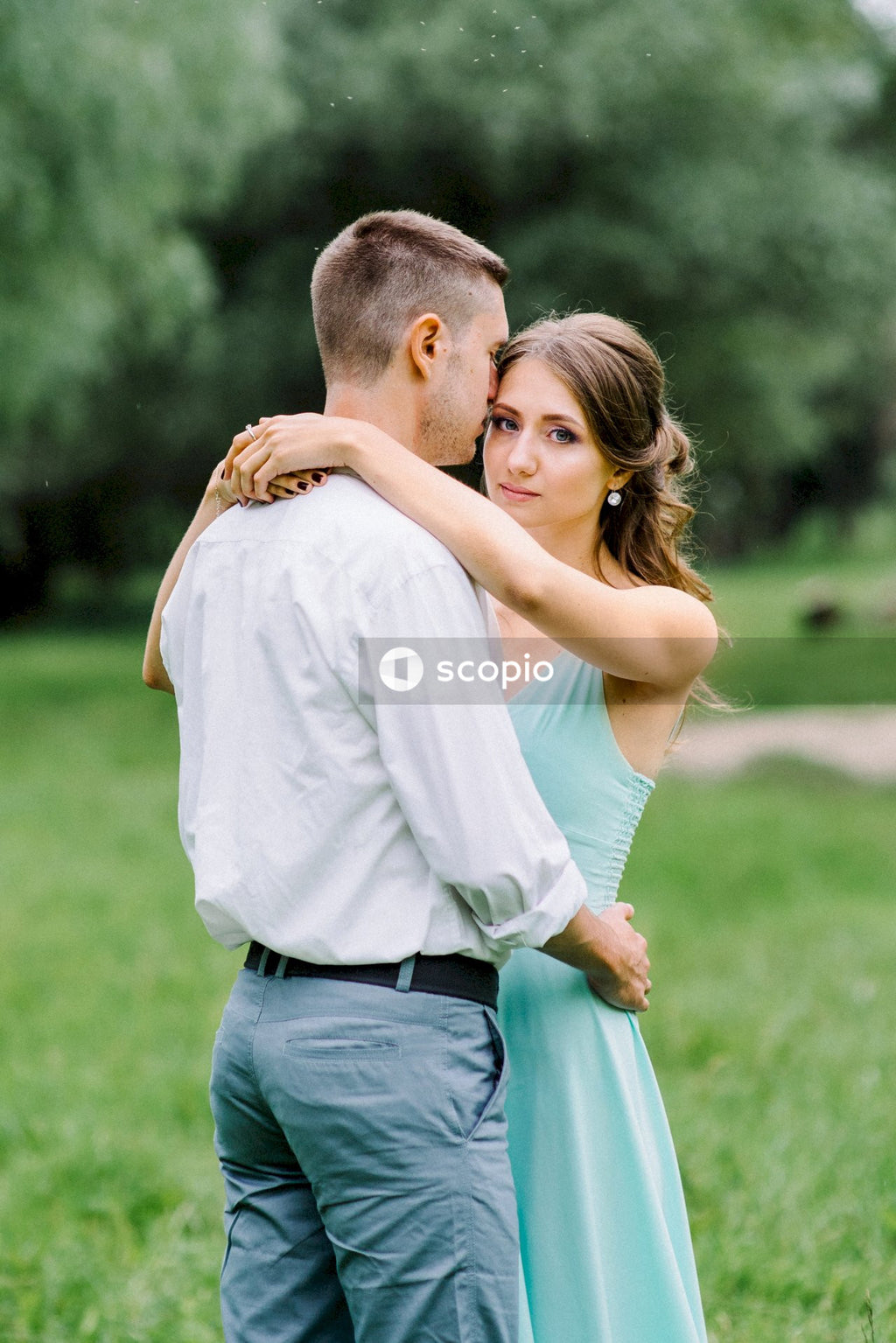 Man in white shirt hugging woman in white shirt