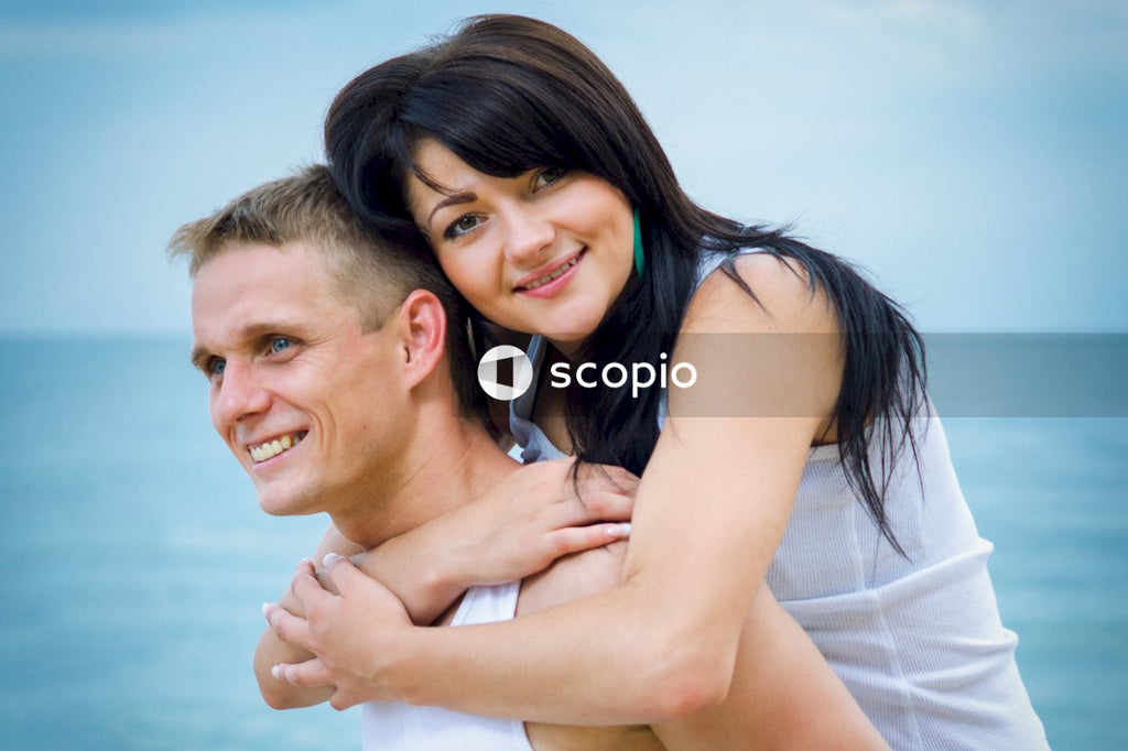 Man in white shirt hugging woman in white tank top