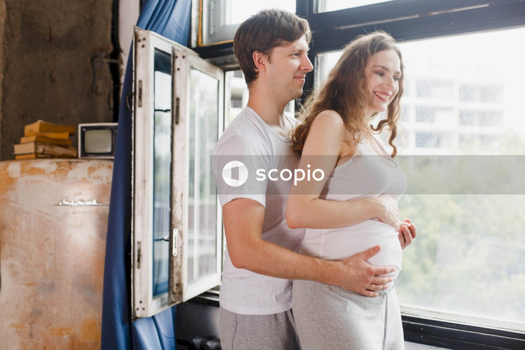 Man in white shirt hugging woman in white tank top