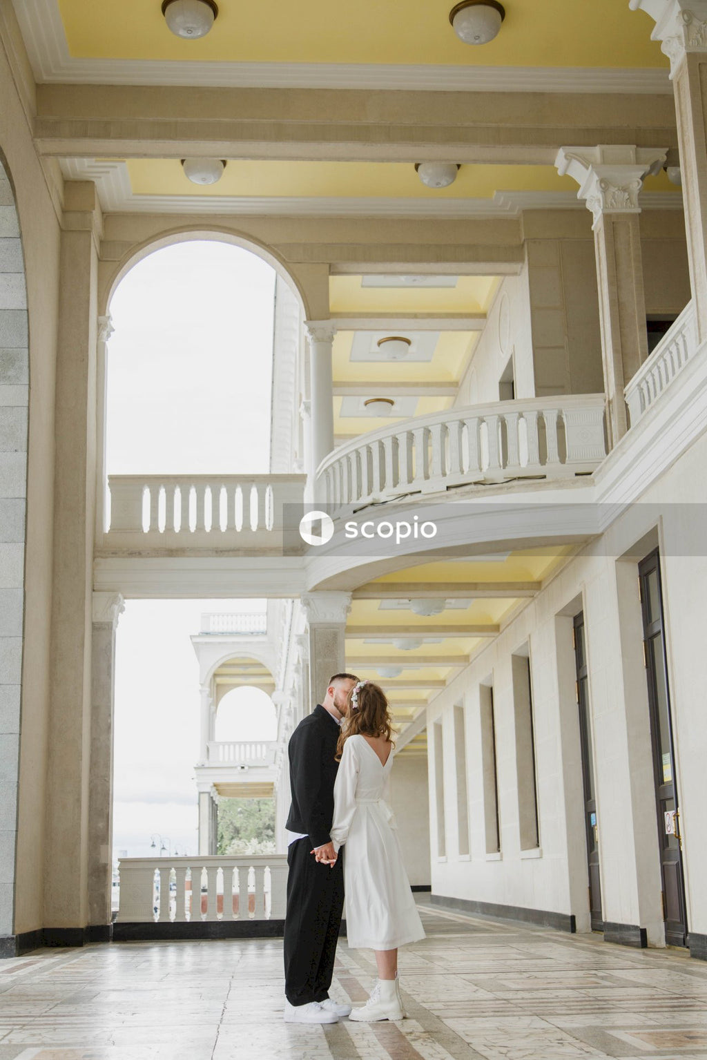 Man in white suit standing with woman in white dress