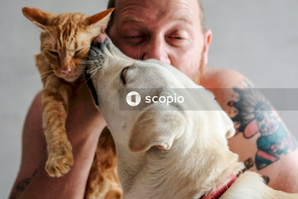 Man in white tank top hugging white short coated dog