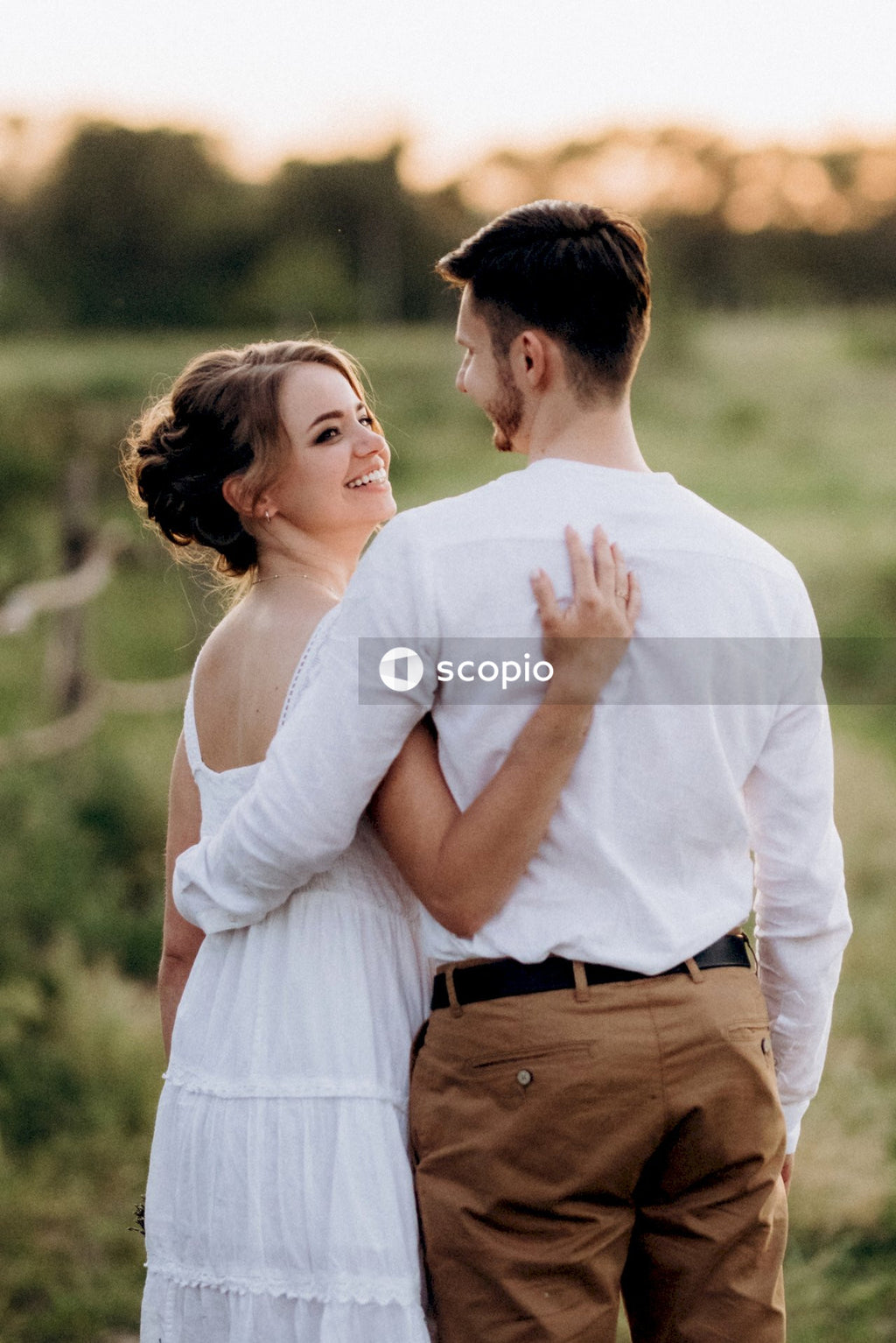 Man in white tank top hugging woman in white tank top