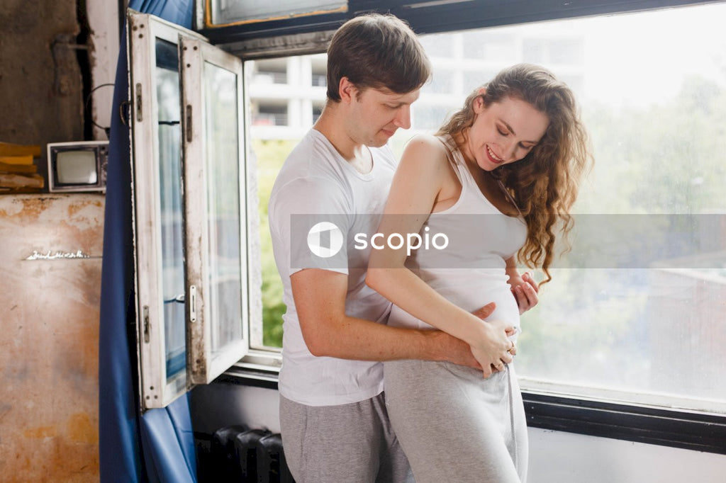 Man in white tank top hugging woman in white tank top