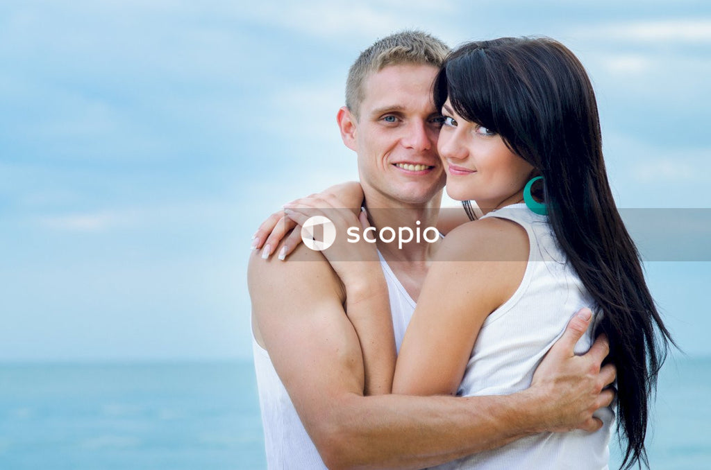 Man in white tank top hugging woman in white tank top