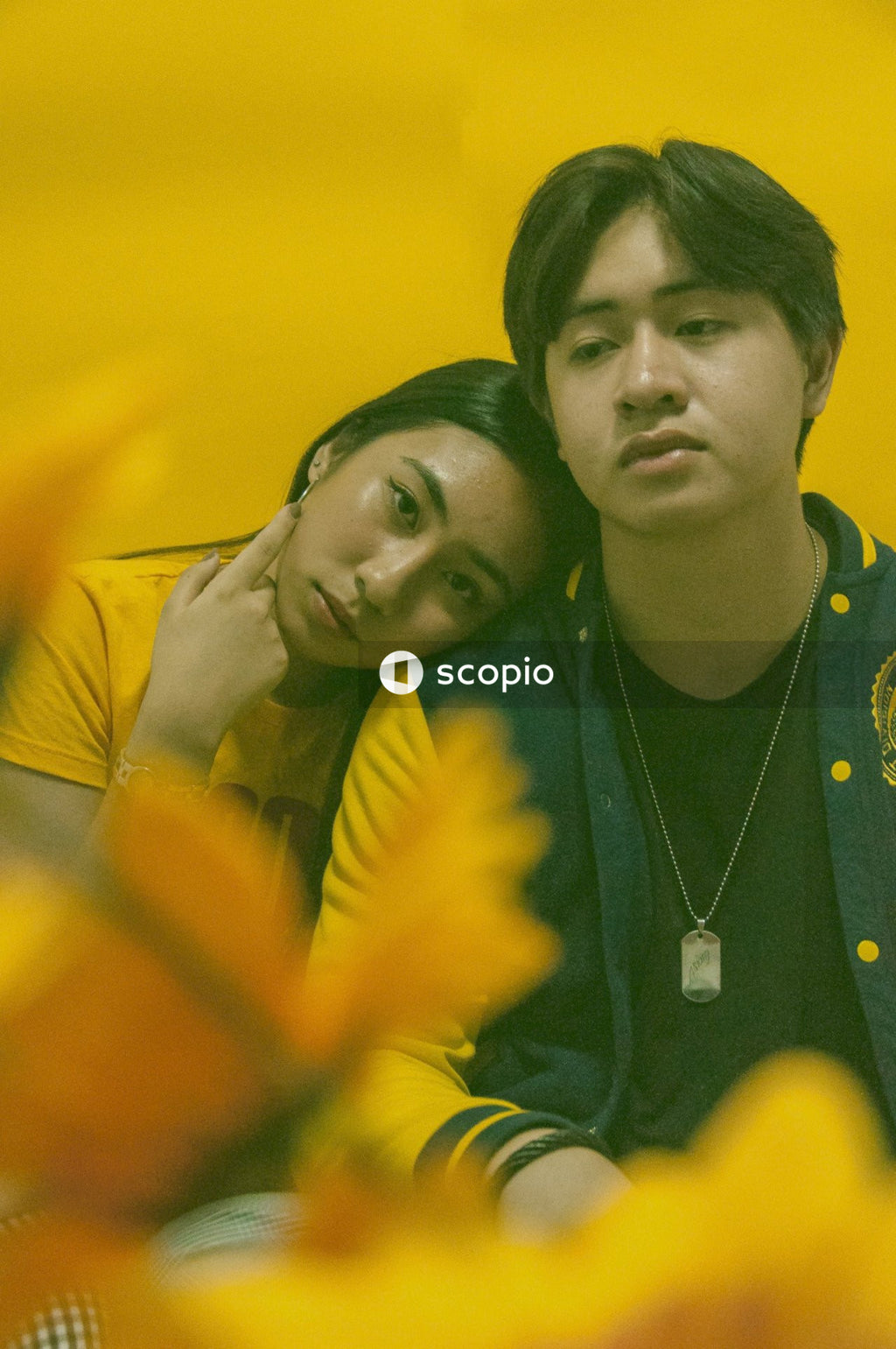 Young Filipino man and woman against yellow background