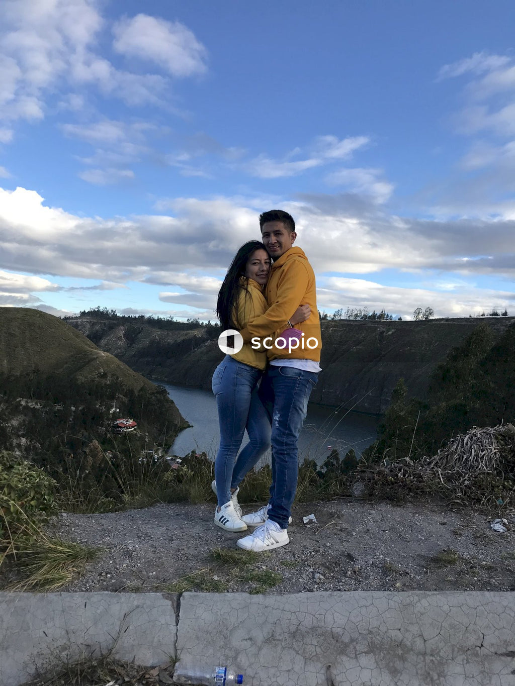 Man and woman in yellow tops standing on mountain