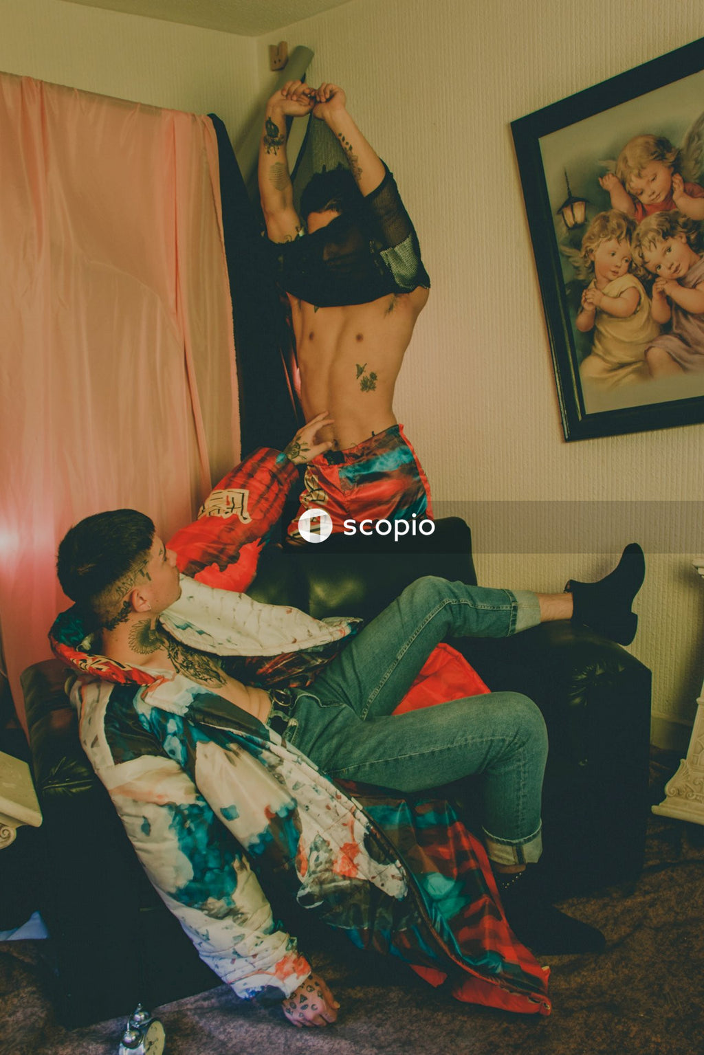 Man taking off his shirt while another man touching his belly