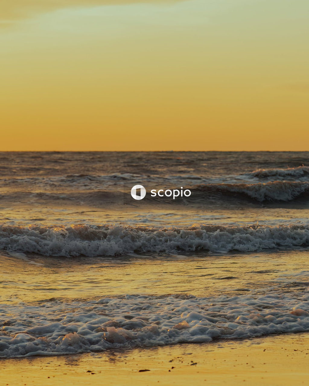 Ocean waves crashing on shore during sunset