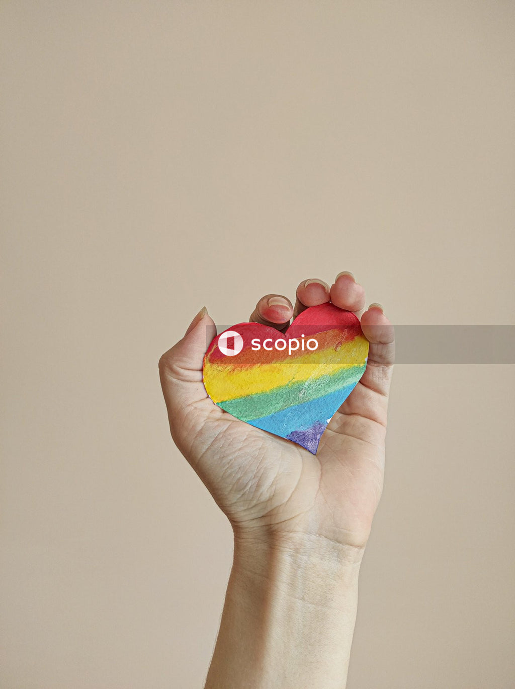 Person holding a rainbow colored heart ornament