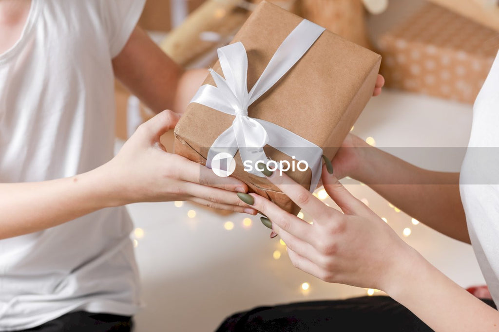 Person holding brown and white gift box