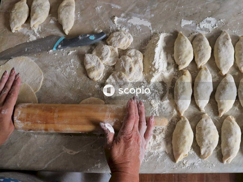 Person holding brown wooden rolling pin