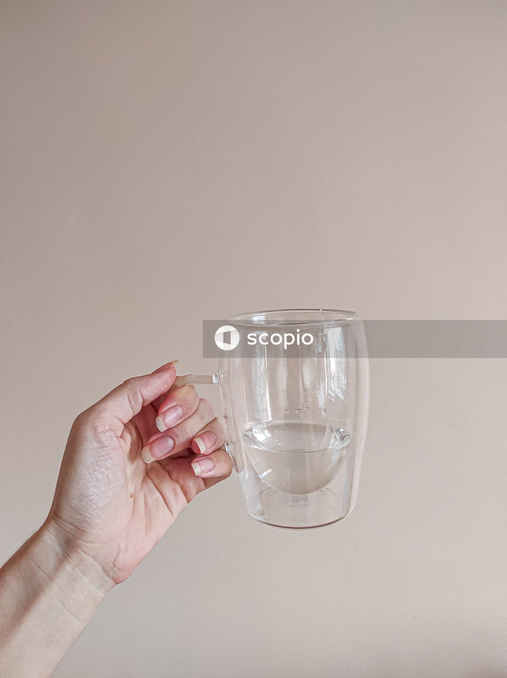 Person holding clear drinking glass