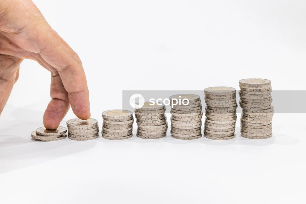 Person holding gold and silver round coins