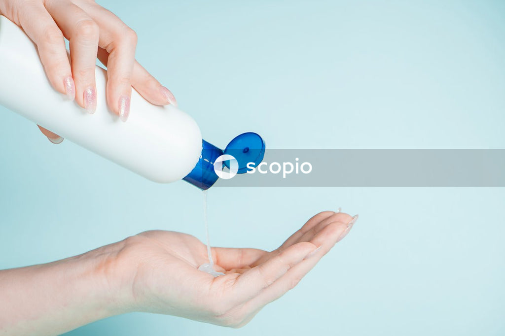 Person holding white and blue plastic bottle