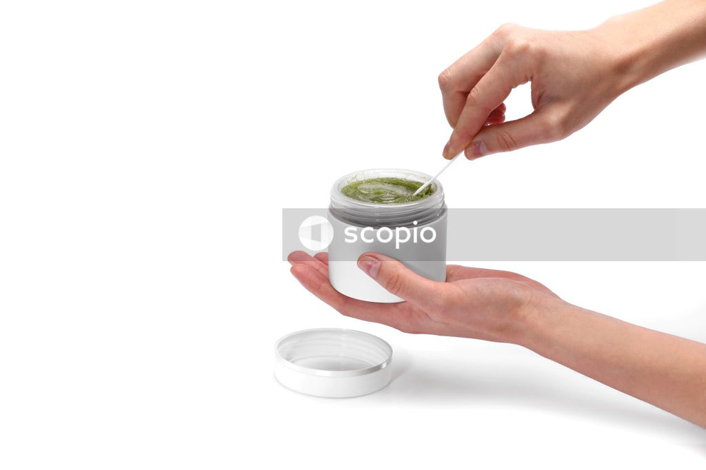 Person holding white and green labeled jar