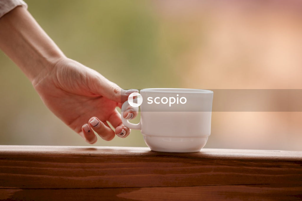 Person holding white ceramic mug