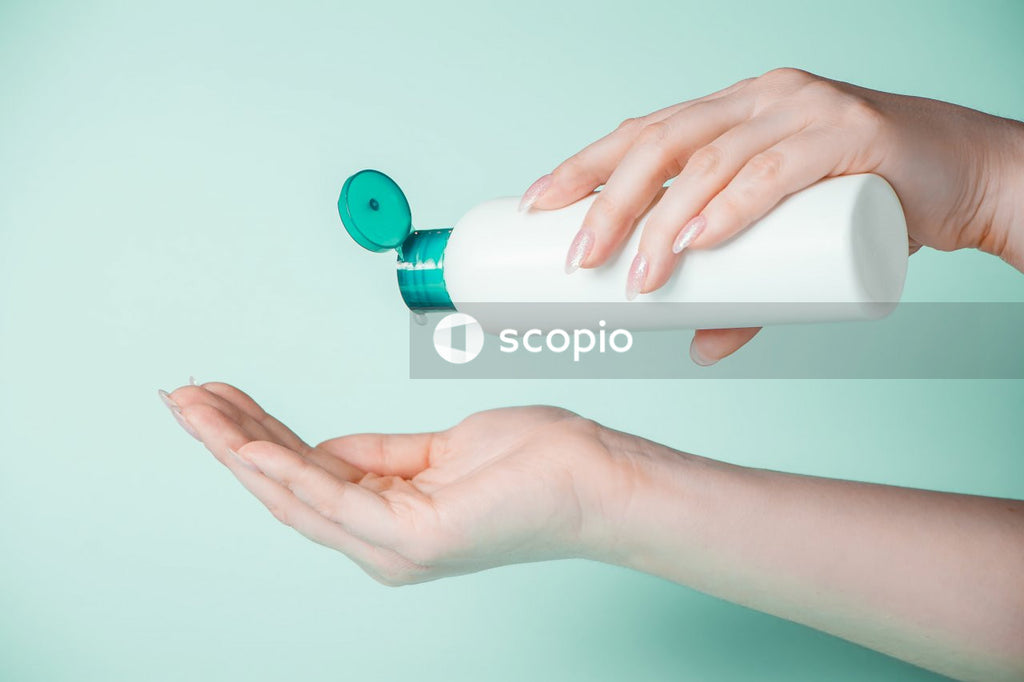 Person holding white plastic bottle