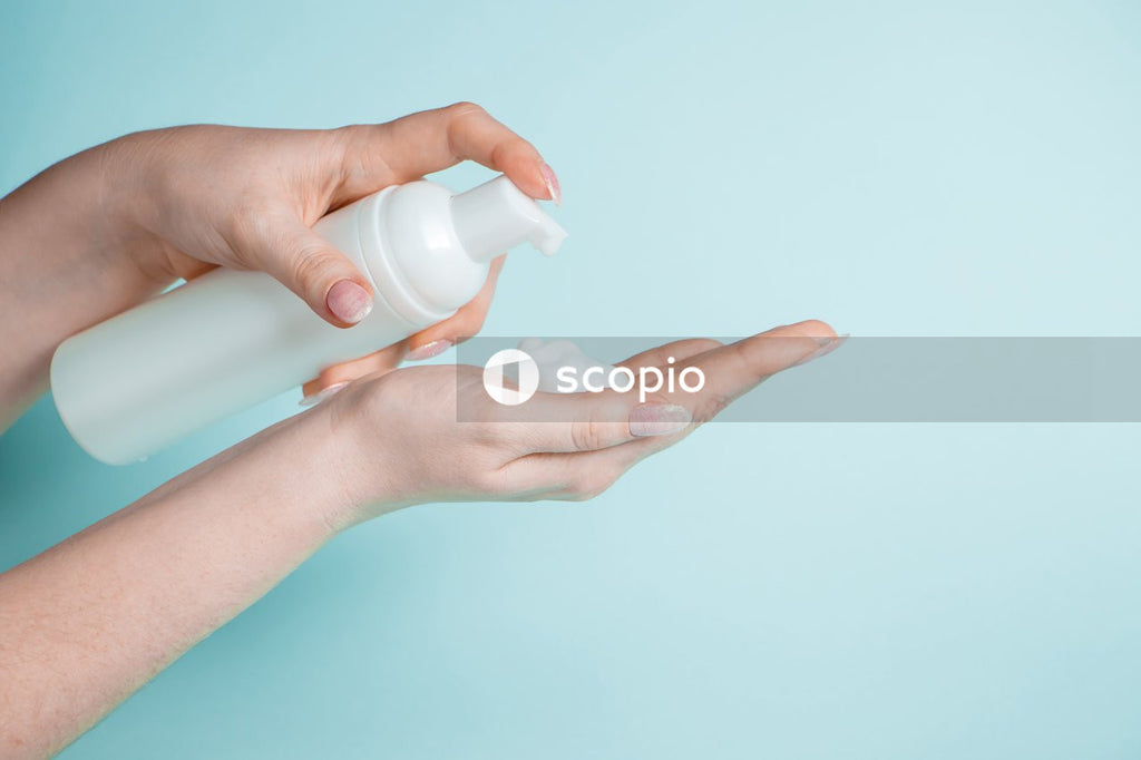 Person holding white plastic bottle