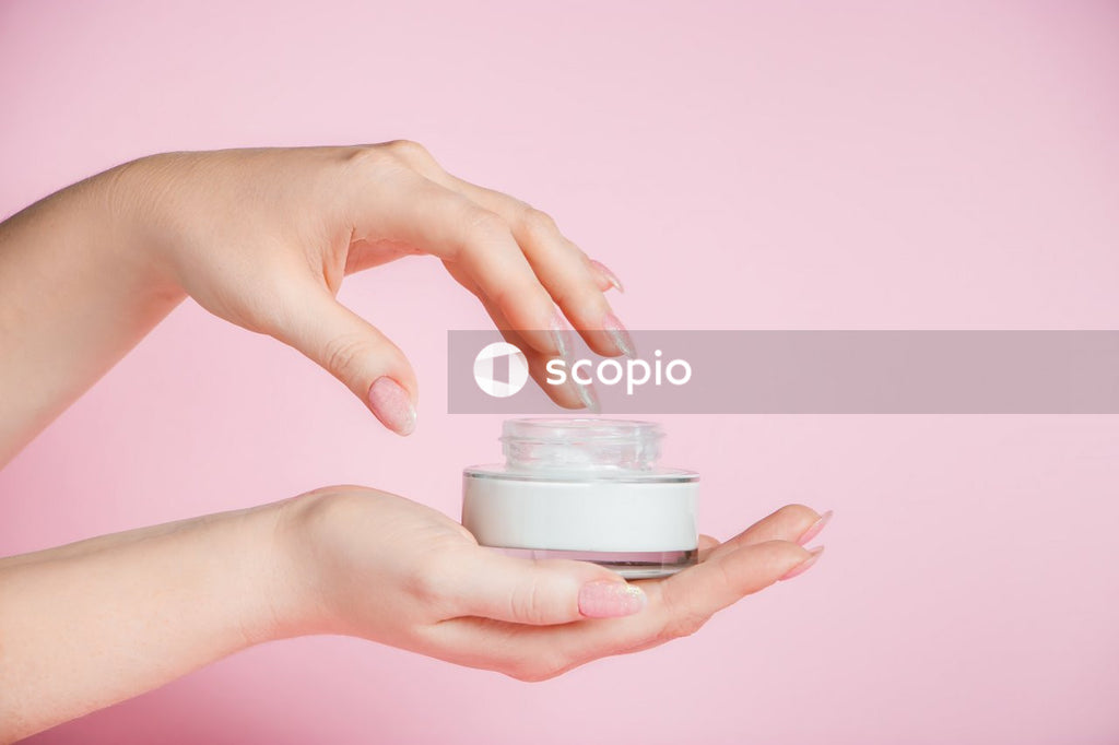 Person holding white round plastic container