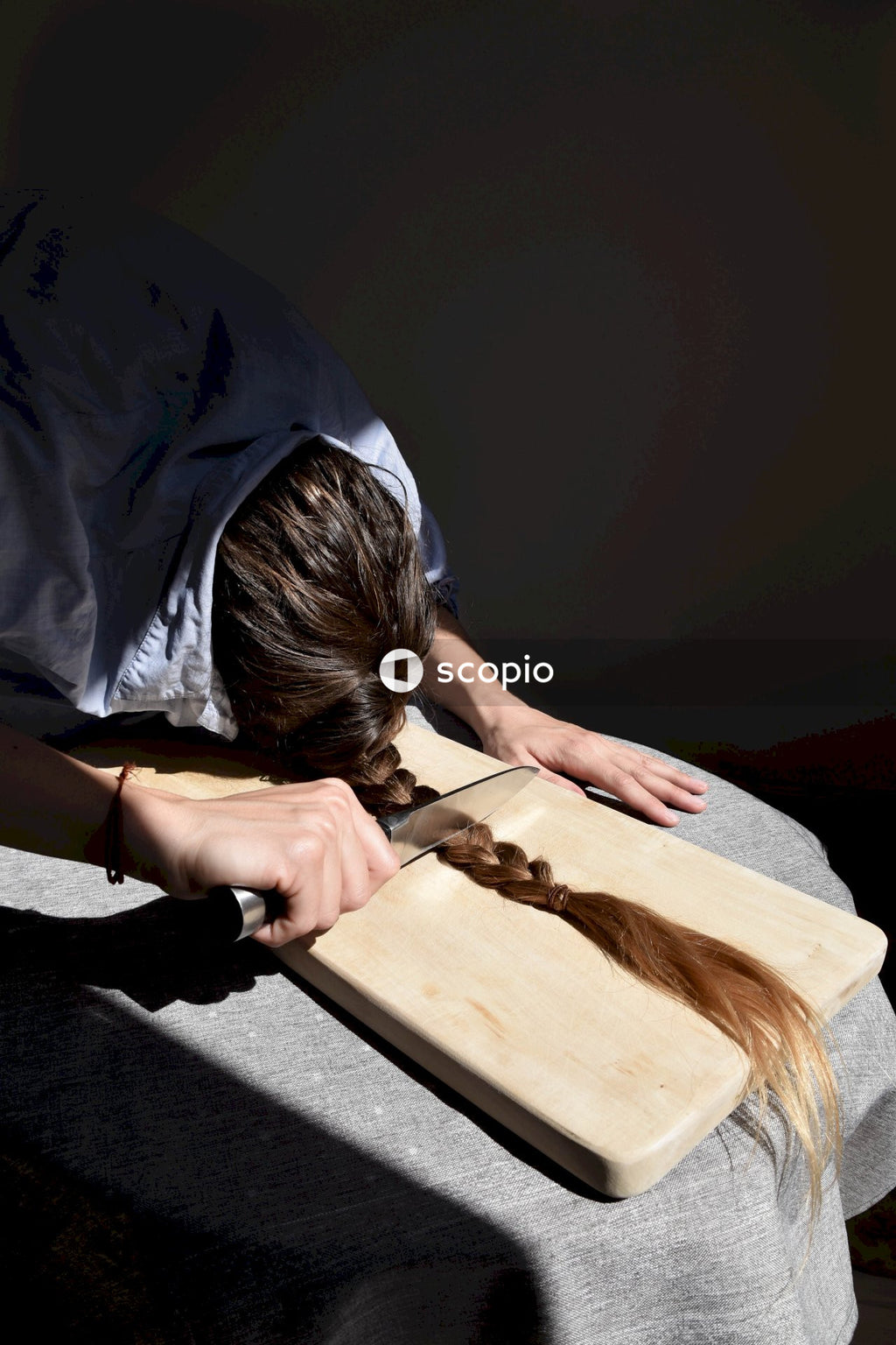 Person in white shirt holding brown wooden chopping board
