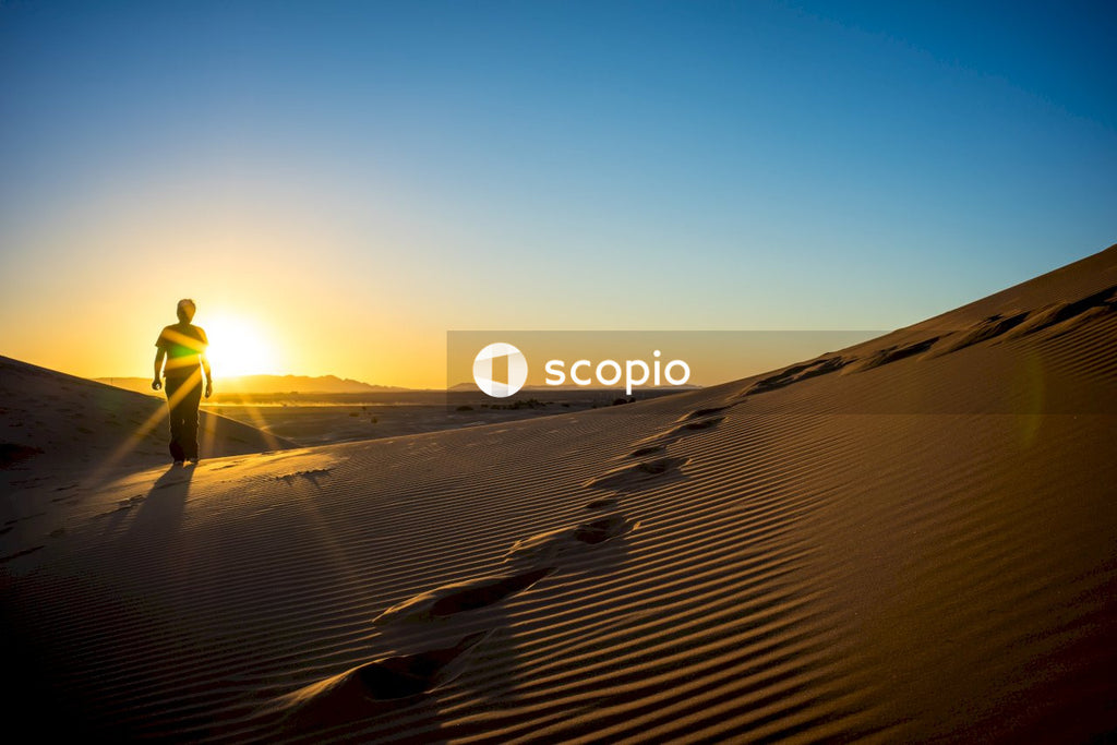 Person in yellow jacket walking on desert