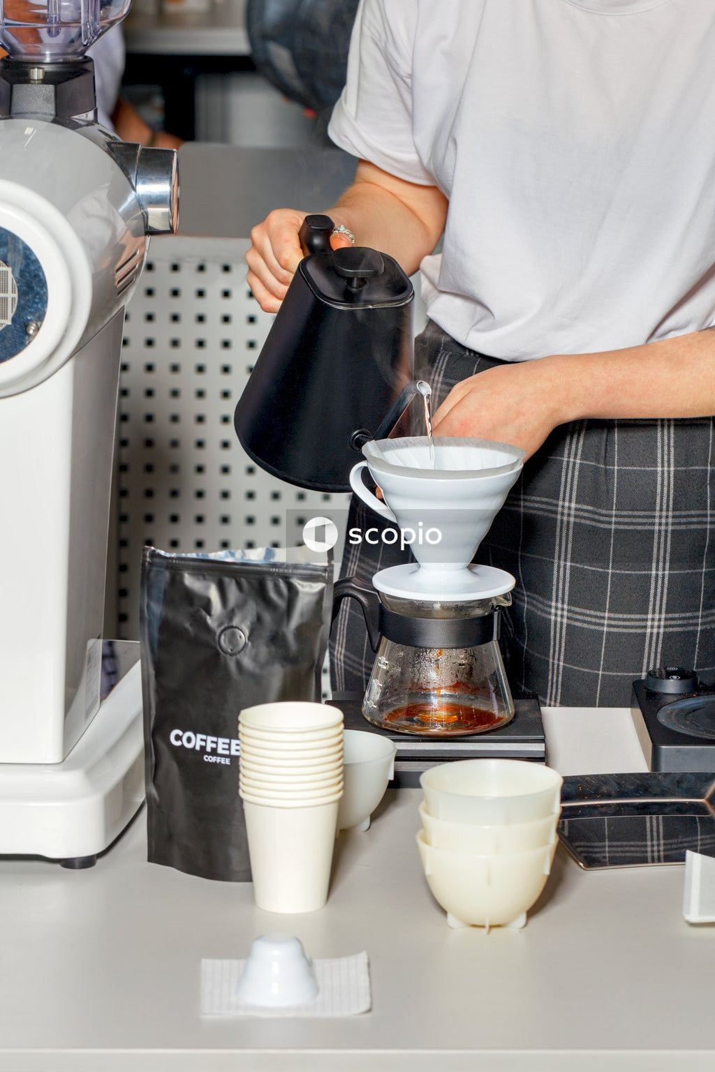 Person pouring coffee on white ceramic mug