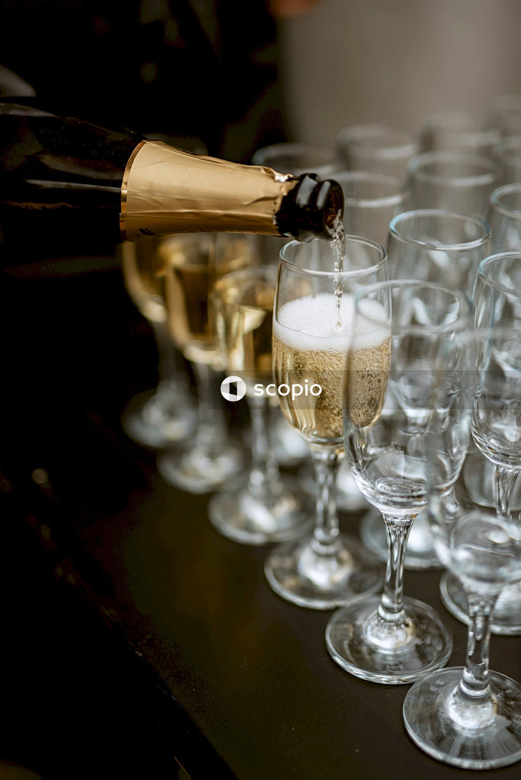 Person pouring wine on clear wine glass