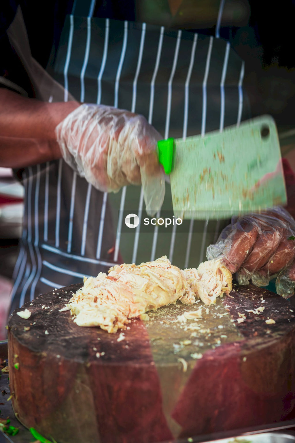 Person slicing meat on brown wooden chopping board