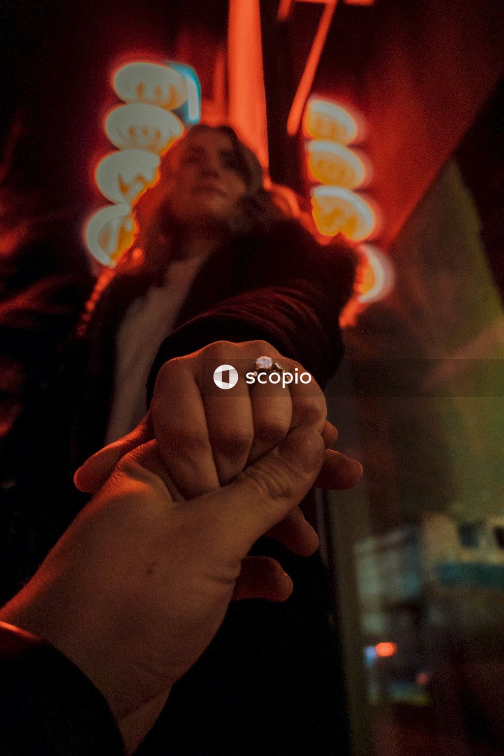 Woman wearing a wedding ring holding a hand outdoors