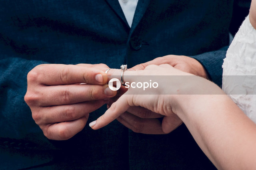 Groom putting a wedding ring on bride's finger
