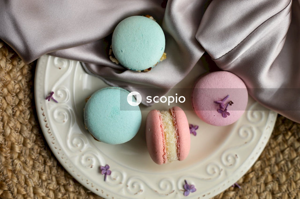 Pink and teal macaroons on white ceramic plate