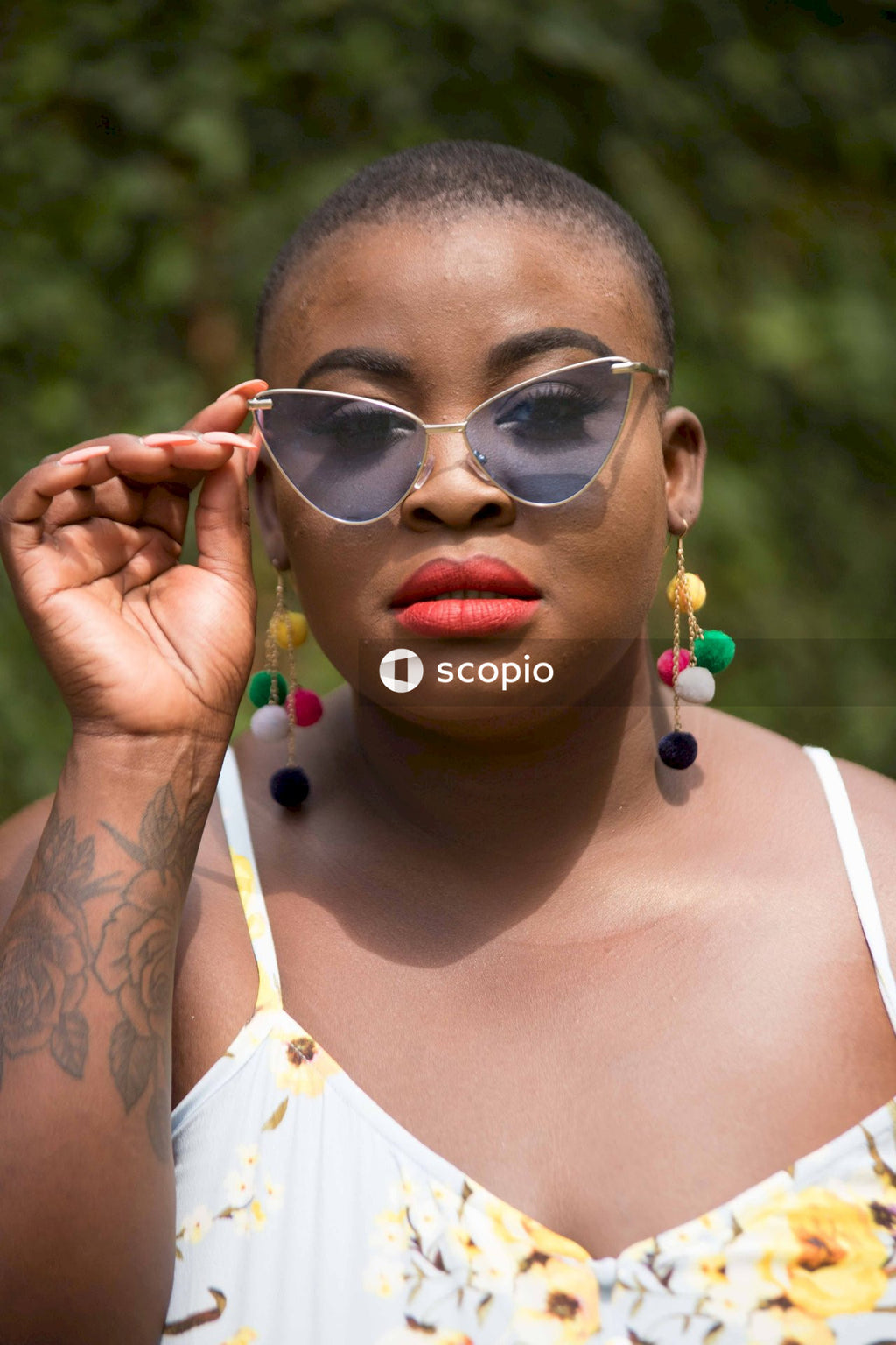 Portrait of woman in white tank top wearing sunglasses outdoor