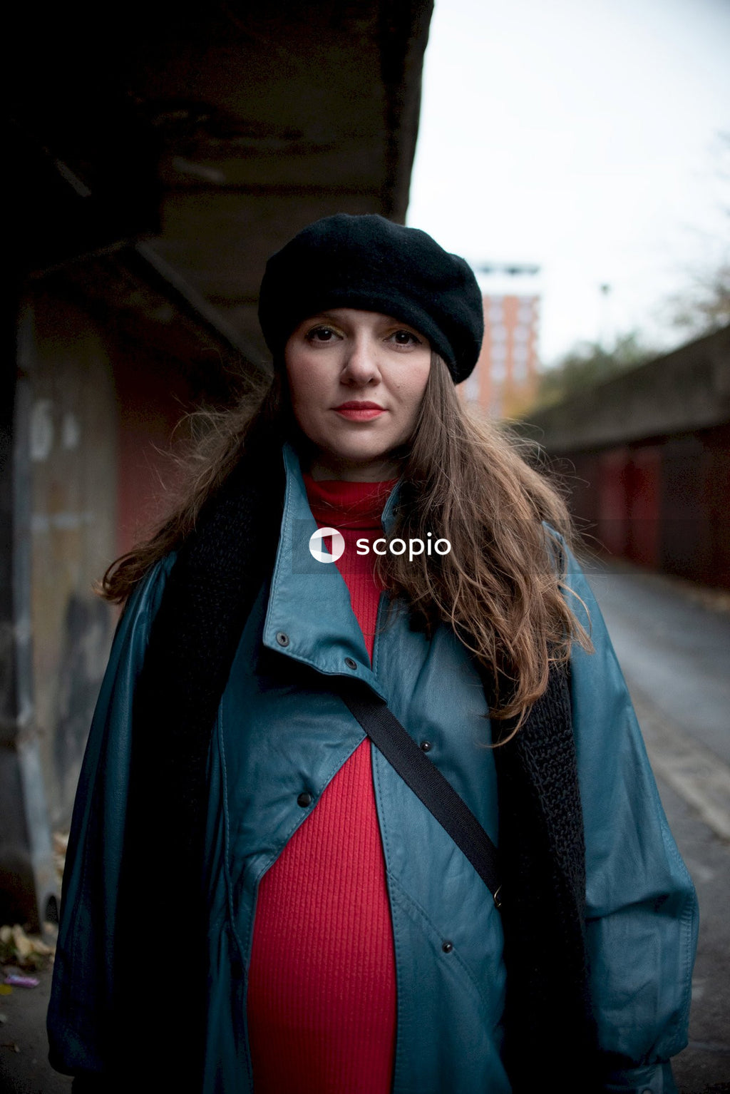 Pregnant woman in black hat and blue coat