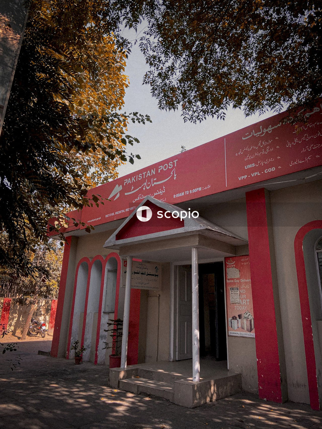 Red and white concrete building near green trees