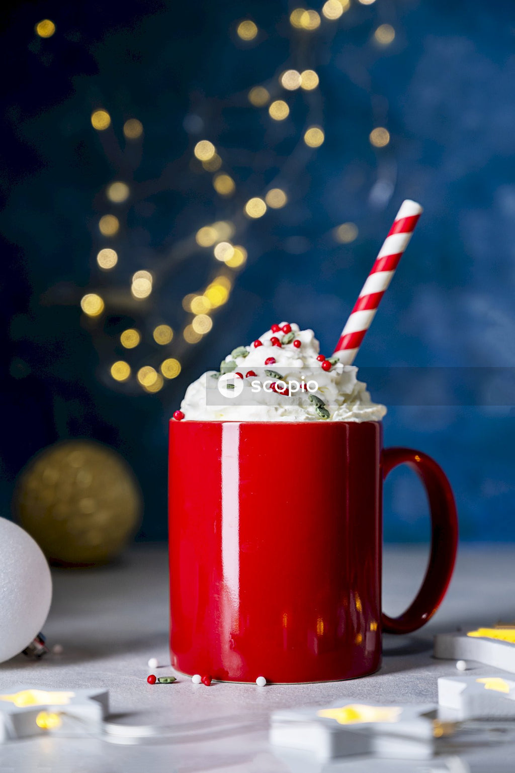 Red ceramic mug with white ice cream and white and red straw