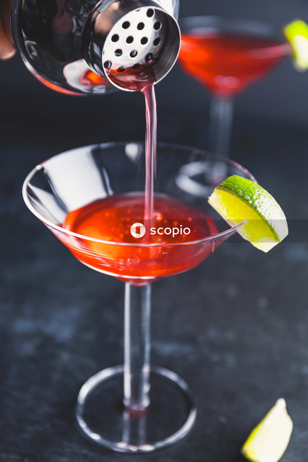 Red liquid in clear drinking glass with sliced lemon