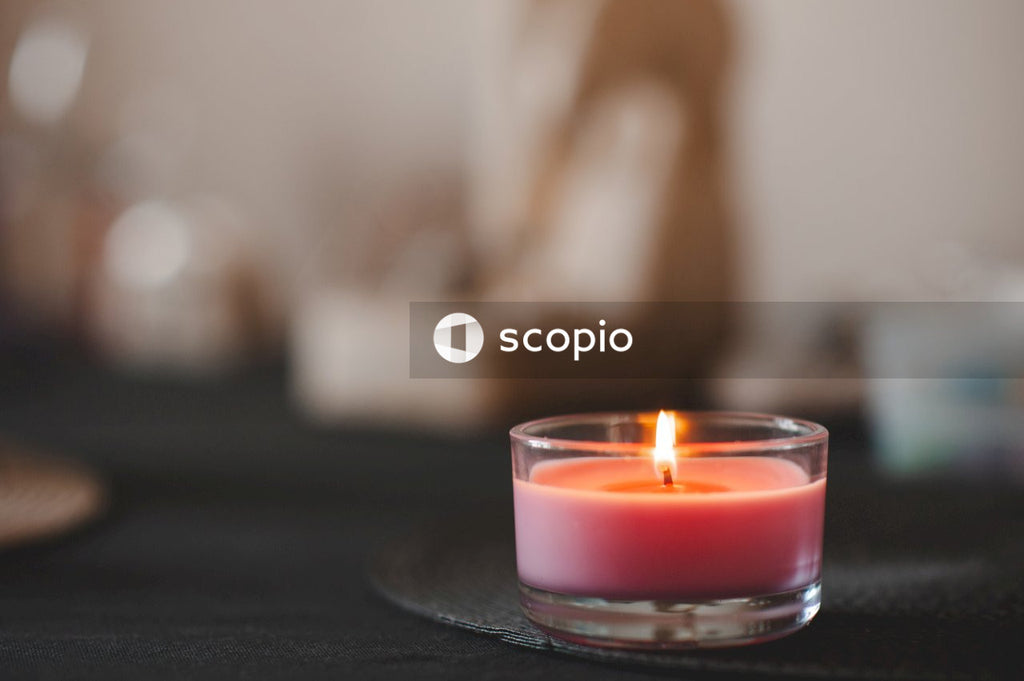 Red scented burning candle on black table