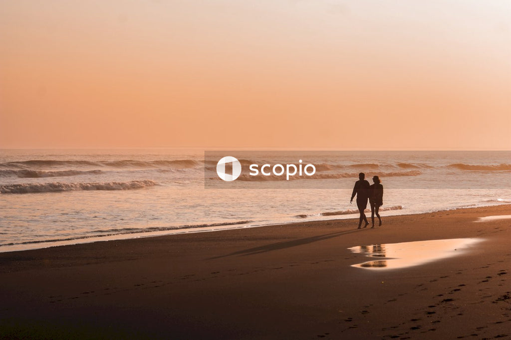 Silhouette of a couple walking on the beach during sunset