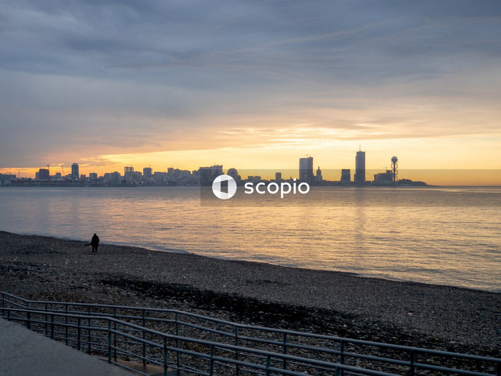 Silhouette of 2 people walking on seashore during sunset