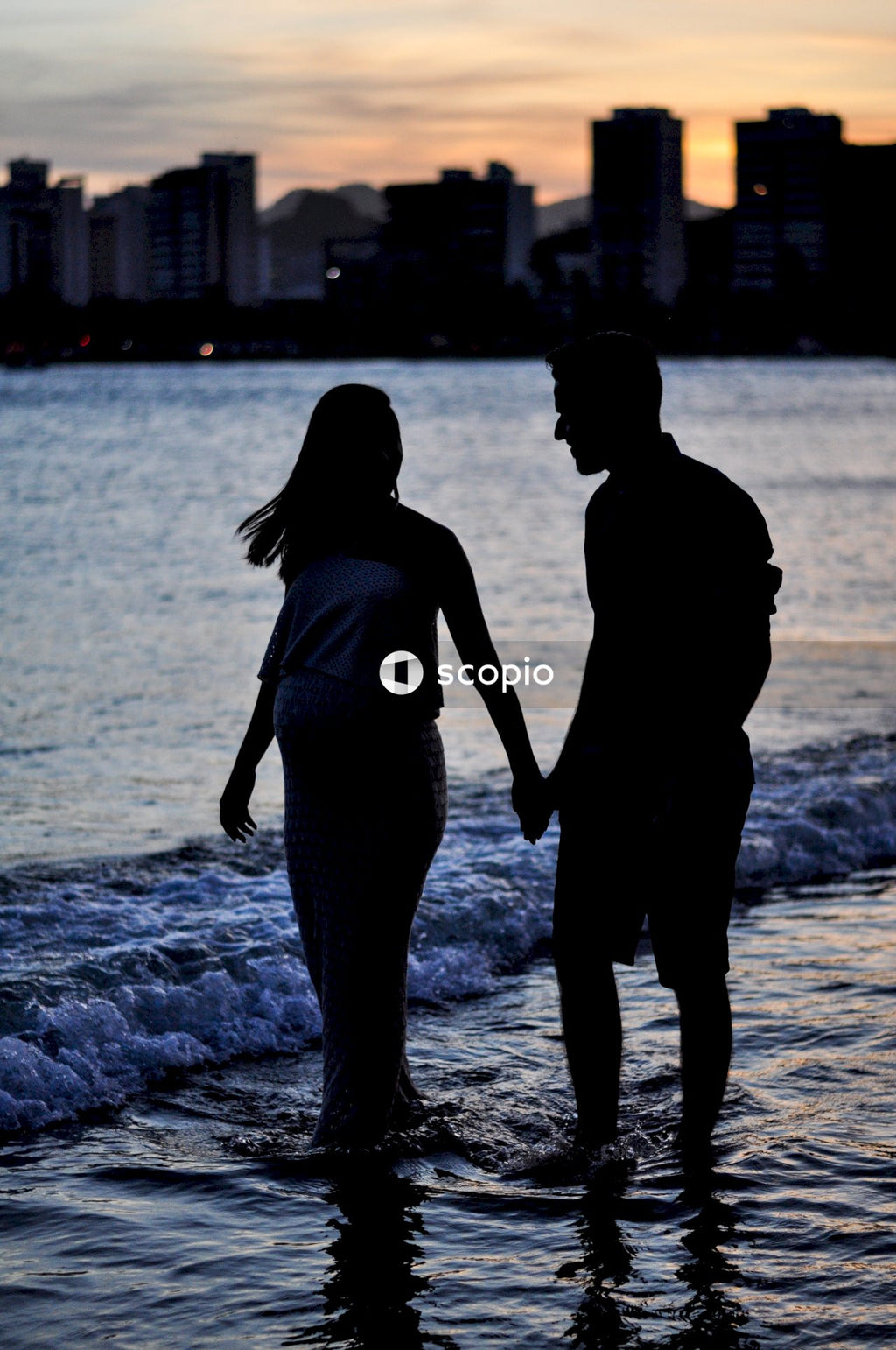 Silhouette of a couple walking on the beach during sunset
