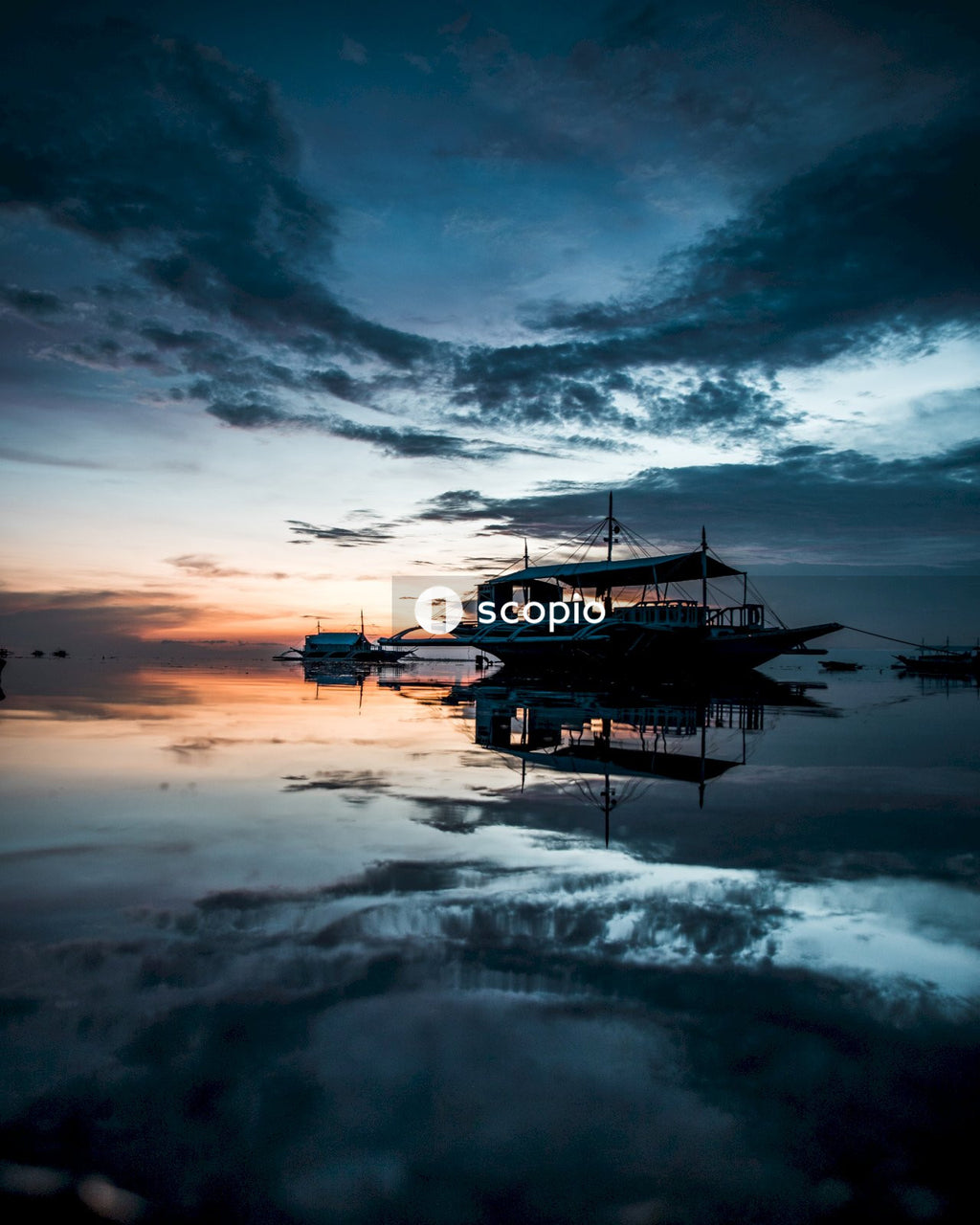 Silhouette of boat on sea under cloudy sky during sunset