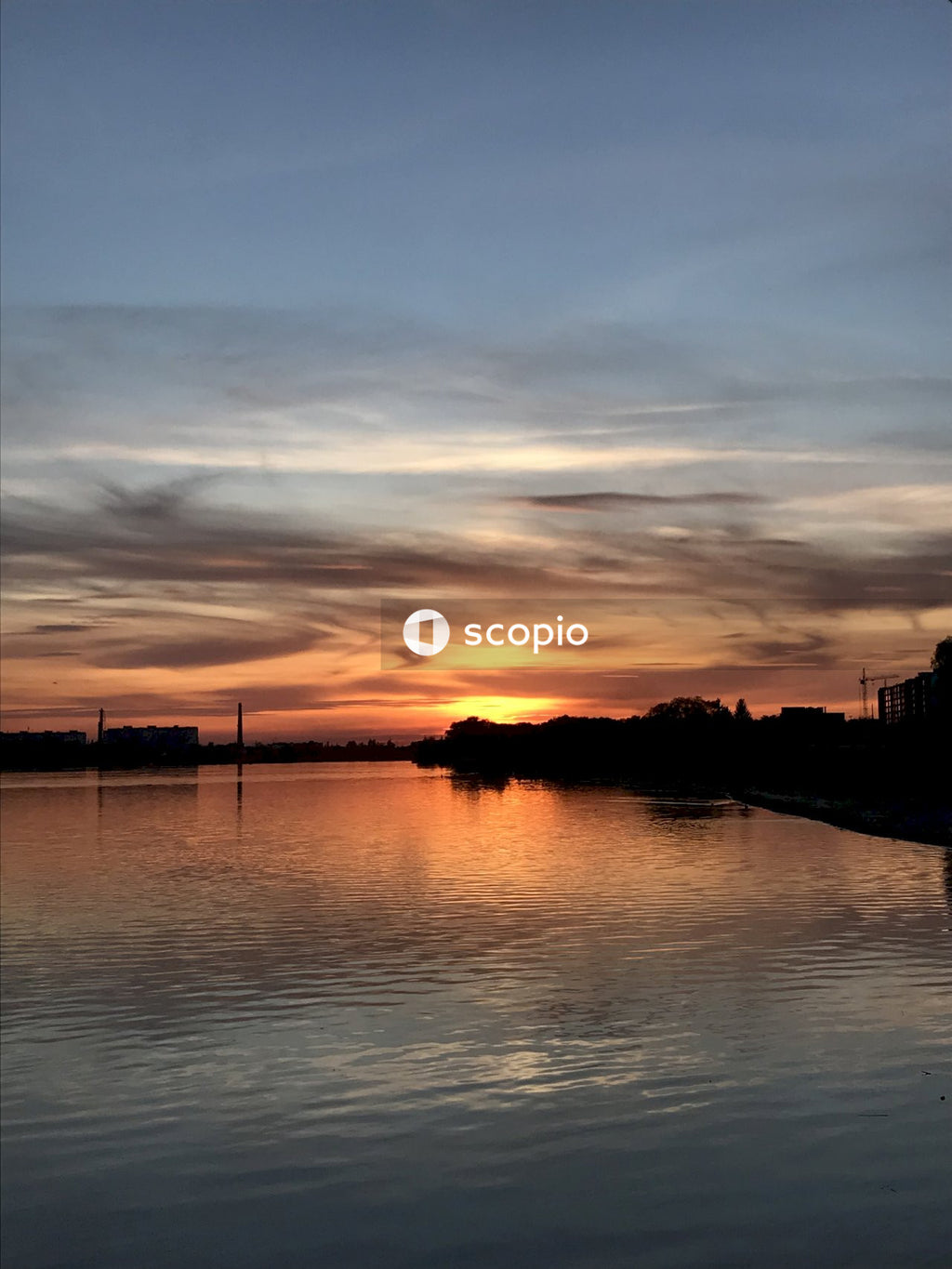 Silhouette of building near body of water during sunset