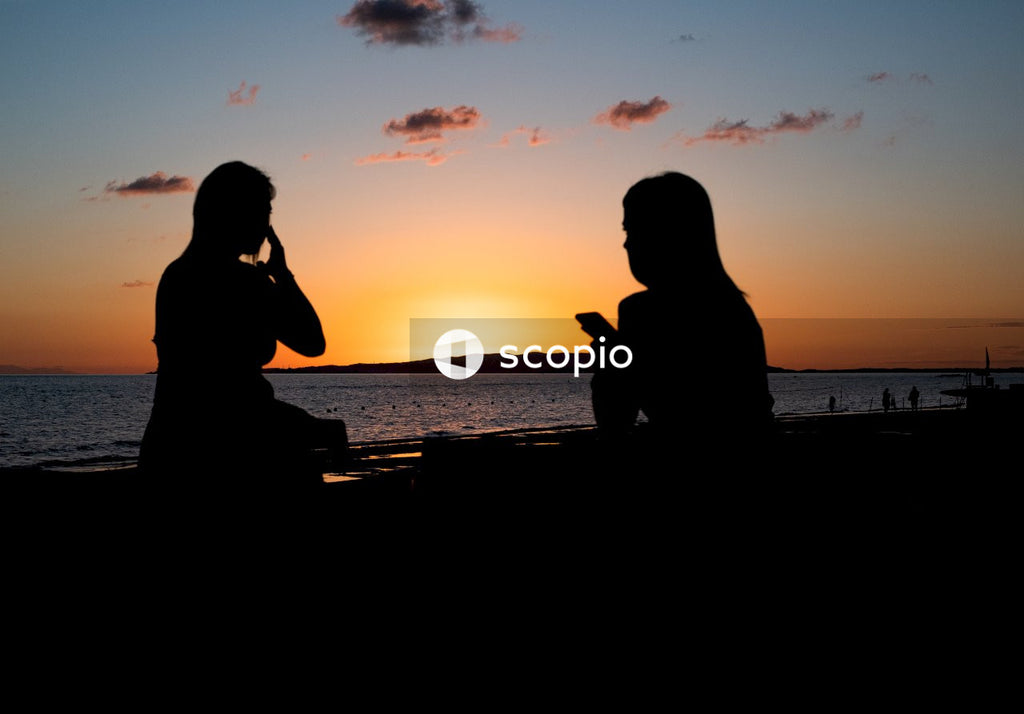 Silhouette of couple sitting on the beach during sunset