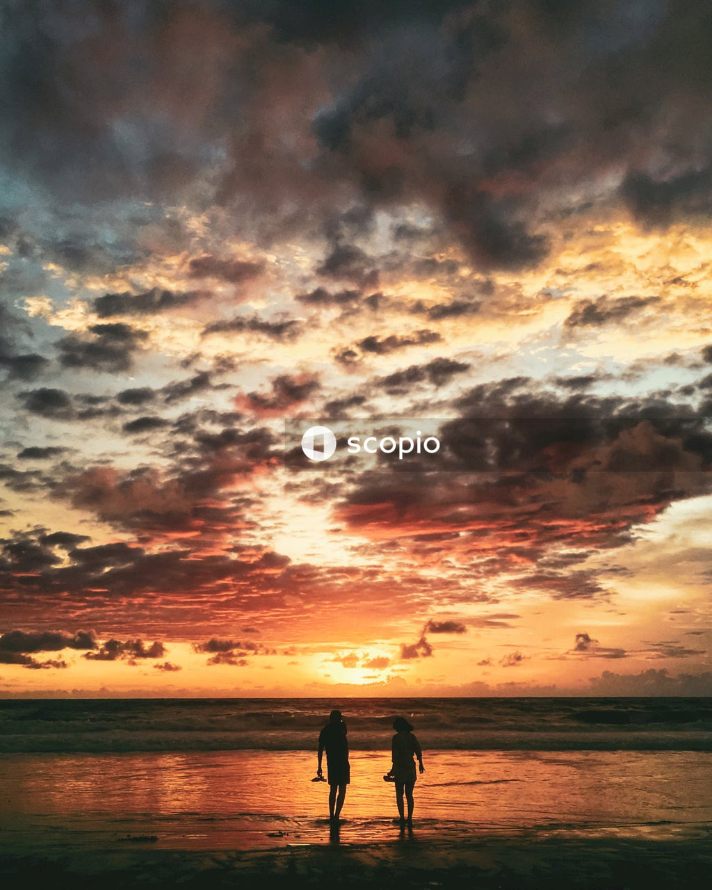 Silhouette of couple standing on beach during sunset