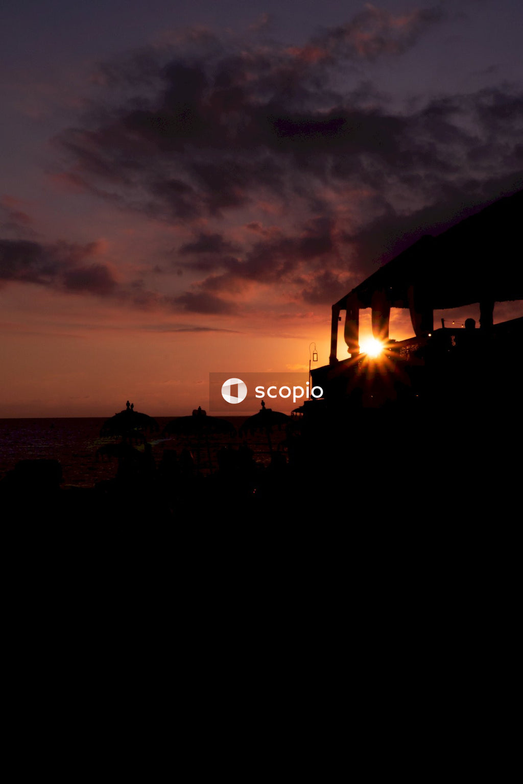 Silhouette of houses near sea during sunset