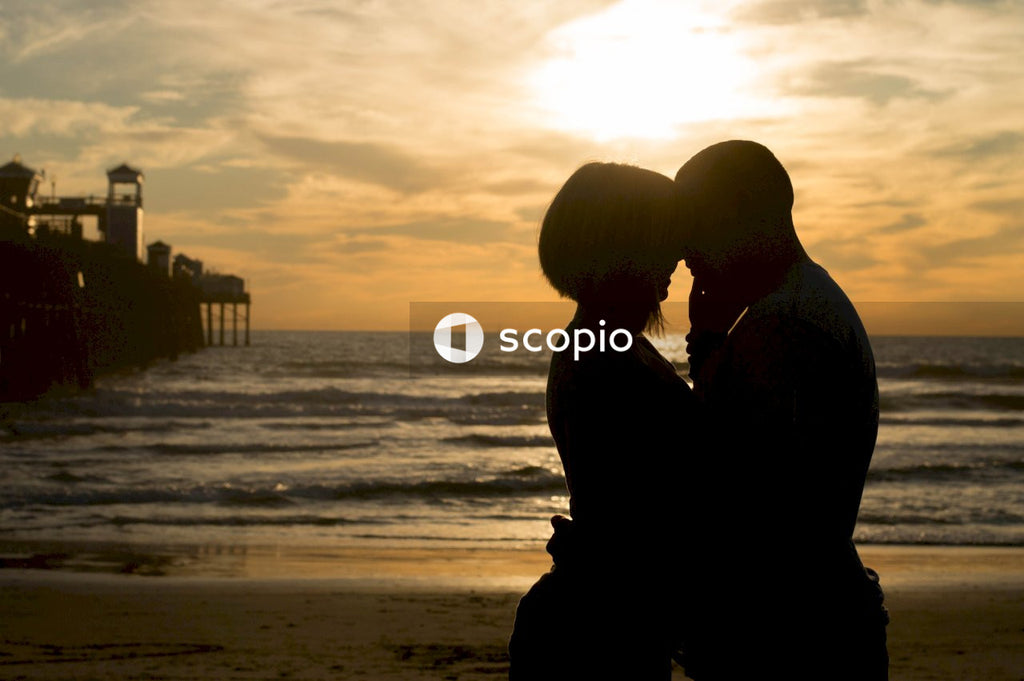 Silhouette of a man and a woman hugging each other at the beach during sunset