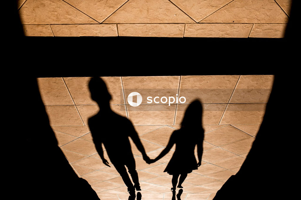 A Shadow of a man and a woman holding hands on the floor