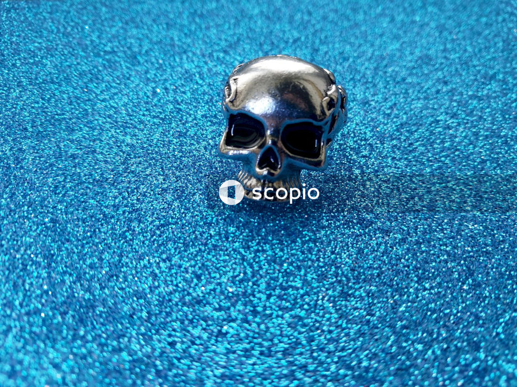 Silver skull ornament on blue textile