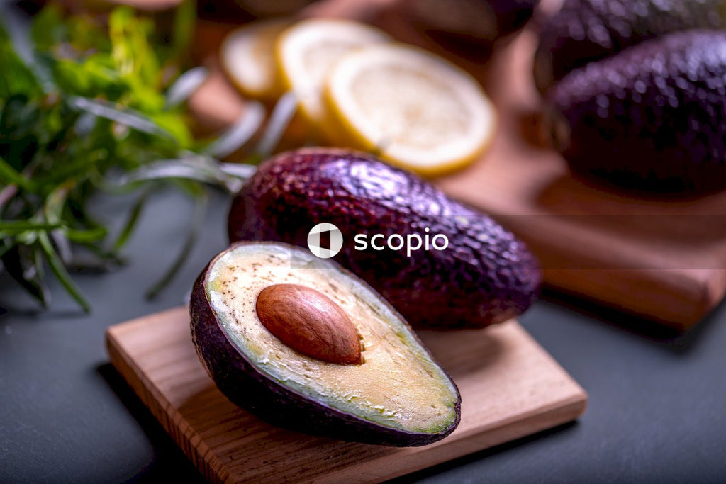 Sliced avocado fruit on brown wooden chopping board